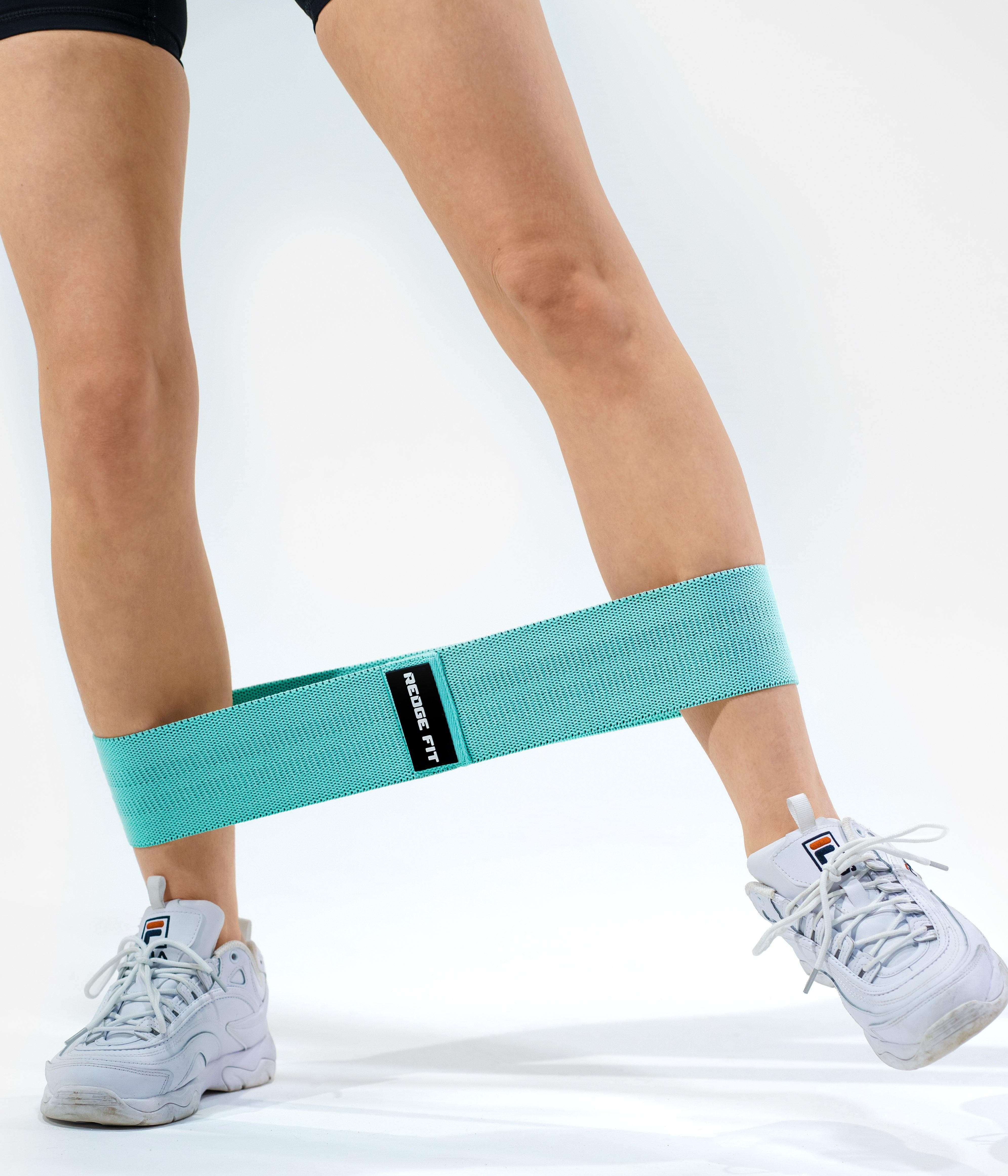 Person modeling Resistance/Sizing: Teal: Heavy weight 18-27kg (40-60lbs), 74cm long and 8cm wide. Material:  40% Cotton, 60% Latex Available at https://www.getredge.com/products/redge-resistance-band-set